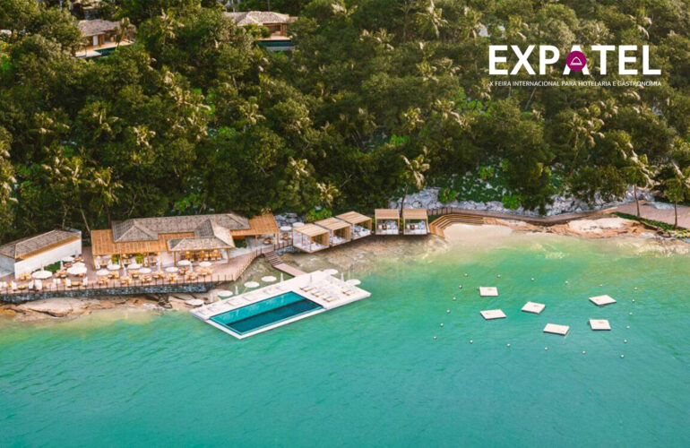 Vista ilustrativa do projeto Hotel Nas Rocas em Búzios, com clube à beira-mar, piscina flutuante e vegetação na Ilha Rasa.